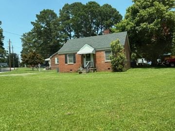 Wilson house for rent - A small brick house with a green lawn in front.