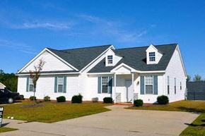 Wake Forest apartment for rent - A white house with a black roof and a grey car parked in front.