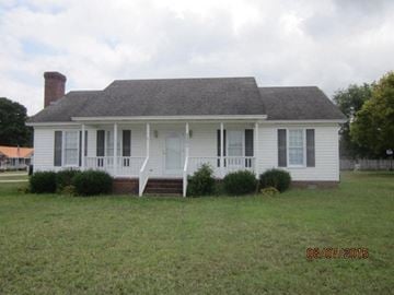 Wilson house for rent - a white house with a lawn in front of it