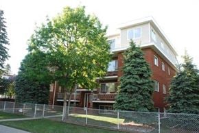 Edmonton apartment for rent - an apartment building with a fence in front of it