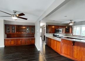 Edmonton apartment for rent - an empty kitchen with wooden cabinets and a ceiling fan