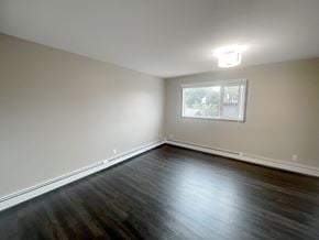 Edmonton apartment for rent - an empty living room with wood floors and a window