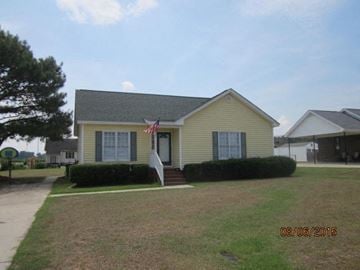 Wilson house for rent - a yellow house with a flag on the front
