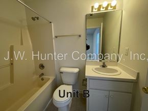 Wilson apartment for rent - A bathroom with a toilet, sink, and bathtub.