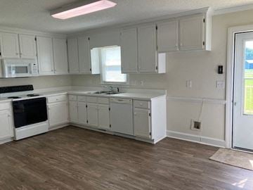 Wilson house for rent - a kitchen with white cabinets and a stove and a sink