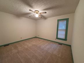 Wilson house for rent - A room with a ceiling fan and carpeted floor.