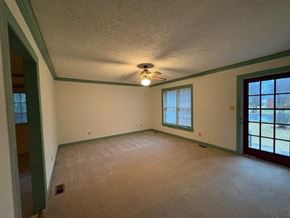 Wilson house for rent - A room with a carpeted floor and a ceiling fan.