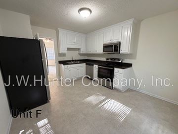 Wilson apartment for rent - A kitchen with white cabinets and a black fridge is shown.
