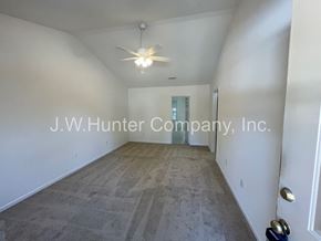 Wilson apartment for rent - A spacious room with a carpeted floor and a ceiling fan.