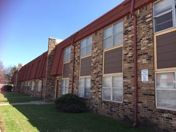 Stillwater apartment for rent - the side of a brick building with a sign on it