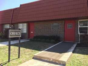 Stillwater apartment for rent - a building with a red door and a sign in front of it