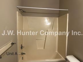Wilson apartment for rent - A white bathroom with a toilet and a shower stall.