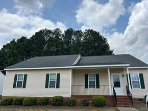 Wilson apartment for rent - A house with a white siding and green shutters.