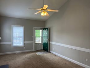 Wilson apartment for rent - A room with a ceiling fan and a door leading to a balcony.