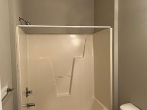 Wilson apartment for rent - A white shower stall with a white toilet in the background.