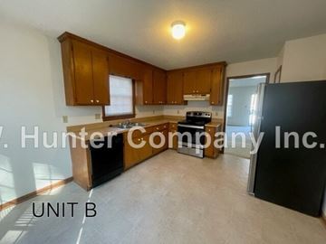 Wilson apartment for rent - A kitchen with wooden cabinets and a black refrigerator is shown.
