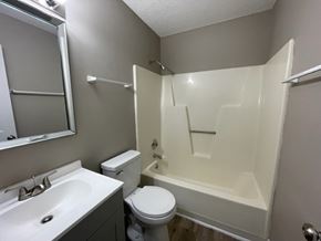 Wilson apartment for rent - A white bathroom with a toilet, sink, and bathtub.