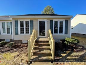 Wilson apartment for rent - A small house with a wooden staircase leading to the front door.