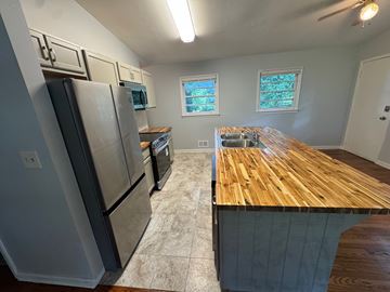 Atlanta house for rent - A kitchen with a wooden counter top and stainless steel appliances.