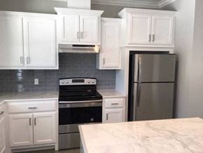 Eunice apartment for rent - A kitchen with white cabinets and a marble countertop.