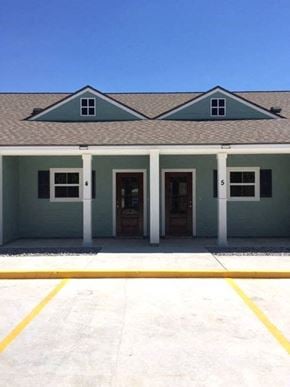 Eunice apartment for rent - A building with a green roof and white columns.