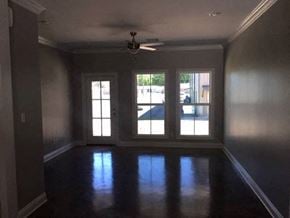 Eunice apartment for rent - A room with a ceiling fan and large windows.