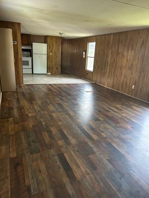 Eunice house for rent - A room with wooden flooring and a white refrigerator.