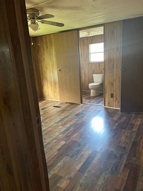 Eunice house for rent - A room with wooden floors and a ceiling fan.