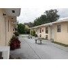 North Miami Beach apartment for rent - A long white road with a white bench on the left and a white trash can on the right.