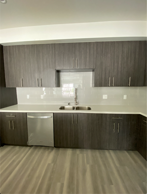 North Hollywood apartment for rent - an empty kitchen with white counter tops and wooden cabinets