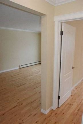 Edmonton apartment for rent - A white door is in a room with wooden floors.