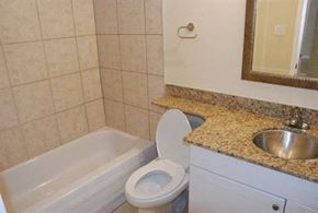 Edmonton apartment for rent - A bathroom with a toilet, sink, and bathtub.