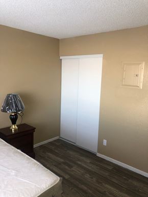 Las Vegas apartment for rent - a bedroom with a white closet and a lamp on a table