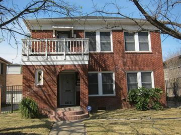 Houston apartment for rent - a brick house with a balcony and a black door