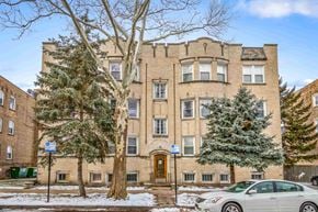 Chicago apartment for rent - A large brown building with a tree in front of it.