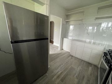 Chicago apartment for rent - A modern kitchen with a stainless steel refrigerator and wooden flooring.