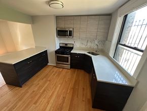 Chicago apartment for rent - an empty kitchen with wooden floors and black cabinets