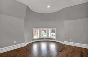 St. Louis apartment for rent - A room with a wooden floor and a large window with pictures on it.