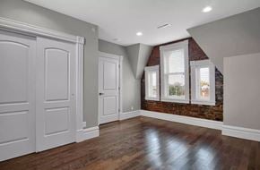 St. Louis apartment for rent - A room with a brick wall and wooden floors.