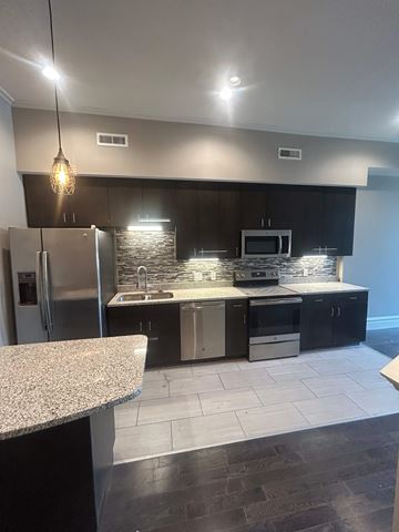 St. Louis apartment for rent - A kitchen with a granite counter top and stainless steel appliances.