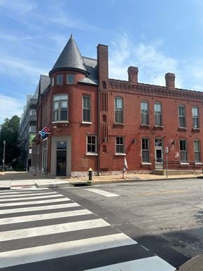St. Louis apartment for rent - A red brick building with a turret sits on a corner.