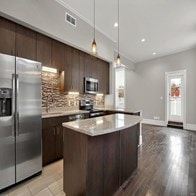 St. Louis apartment for rent - A modern kitchen with a stainless steel refrigerator and wooden cabinets.