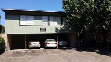 Houston apartment for rent - a building with three cars parked in a parking lot