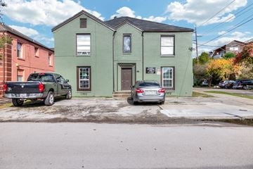 Houston apartment for rent - a green house with two cars parked in front of it