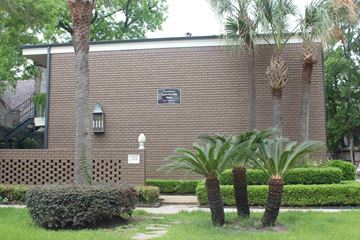 Houston apartment for rent - a brick building with palm trees in front of it