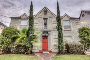 Houston apartment for rent - a white brick house with a red door and palm trees