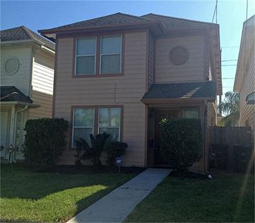 Houston house for rent - a tan house with a sidewalk in front of it