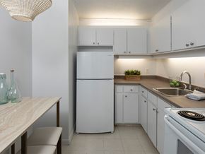 Gatineau apartment for rent - a kitchen with white cabinets and a sink and a refrigerator
