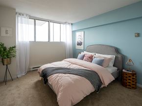 Gatineau apartment for rent - a bedroom with a bed and a blue wall and a window