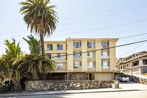 Oakland apartment for rent - A building with a palm tree in front of it.